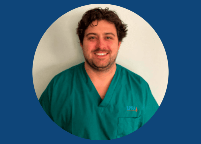 A person wearing a green medical scrub top with the EPPA Health logo, smiling at the camera, is set against a plain background and surrounded by a blue circular border.