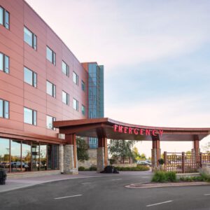 Exterior view of a hospital building, showcasing its iconic red "Emergency" sign above the entrance. Large windows on the upper floors reflect EPPA Health's commitment to excellence, making it one of the leading Minnesota Hospitals for specialized emergency room care.