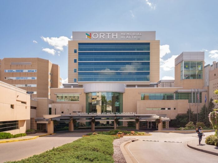 Exterior view of North Memorial Health hospital building on a sunny day, showcasing modern architecture under a clear blue sky. As one of the leading Minnesota Hospitals, it stands as a beacon of care and expertise.