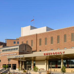A hospital building with a visible sign reading "Emergency South Entrance" under clear blue skies, showcasing the expertise of EPPA Health's renowned emergency room physicians.