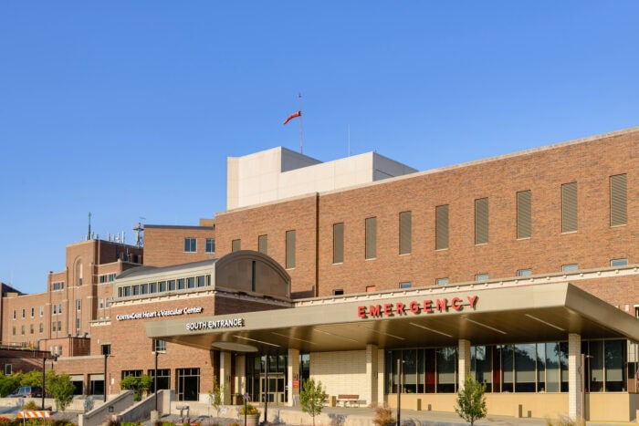 A hospital building with a visible sign reading "Emergency South Entrance" under clear blue skies, showcasing the expertise of EPPA Health's renowned emergency room physicians.